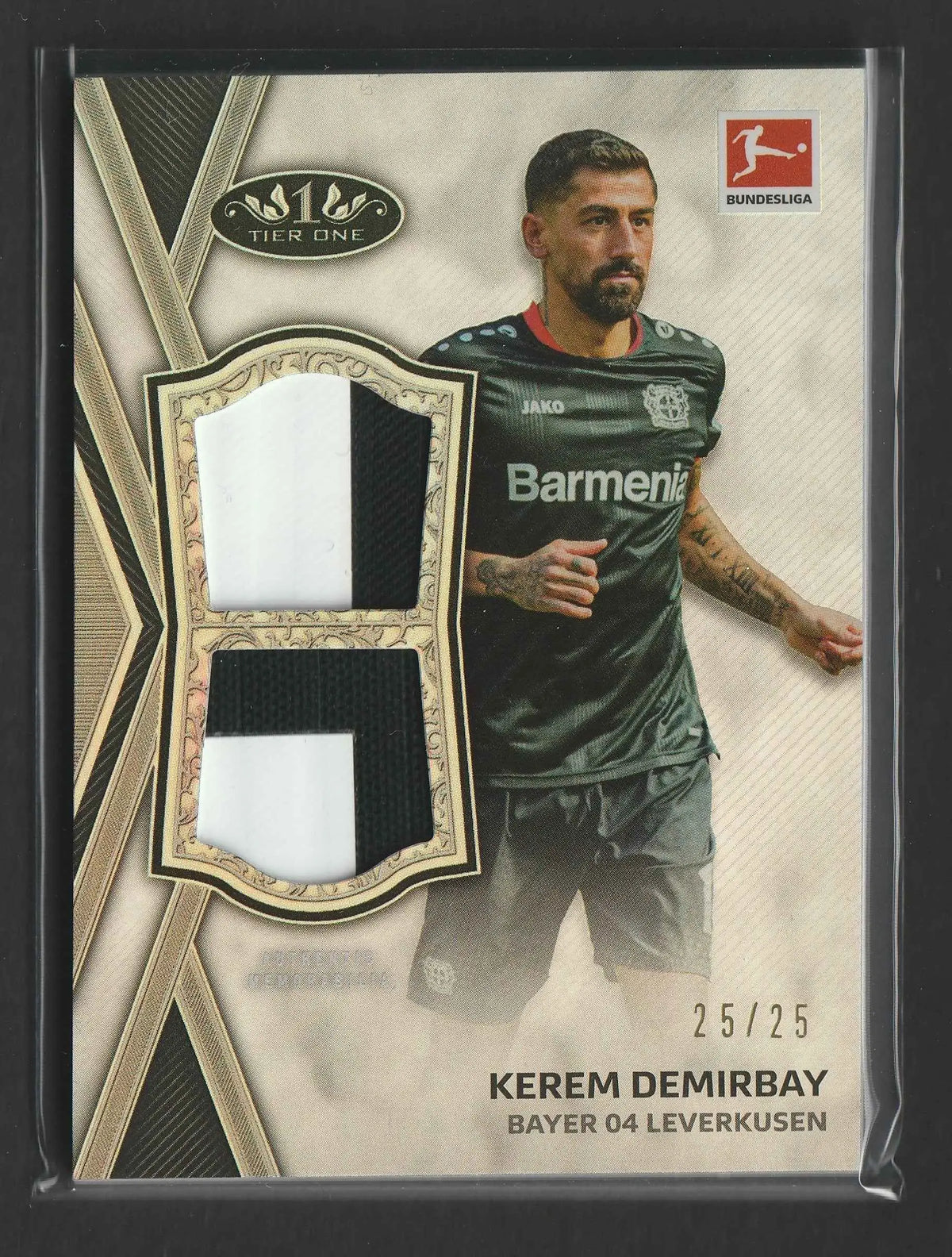 This kerem demirbay 2020/21 topps tier one bundesliga dual relic card features two patches from bayer 04 leverkusen jersey in white and black within a gold border