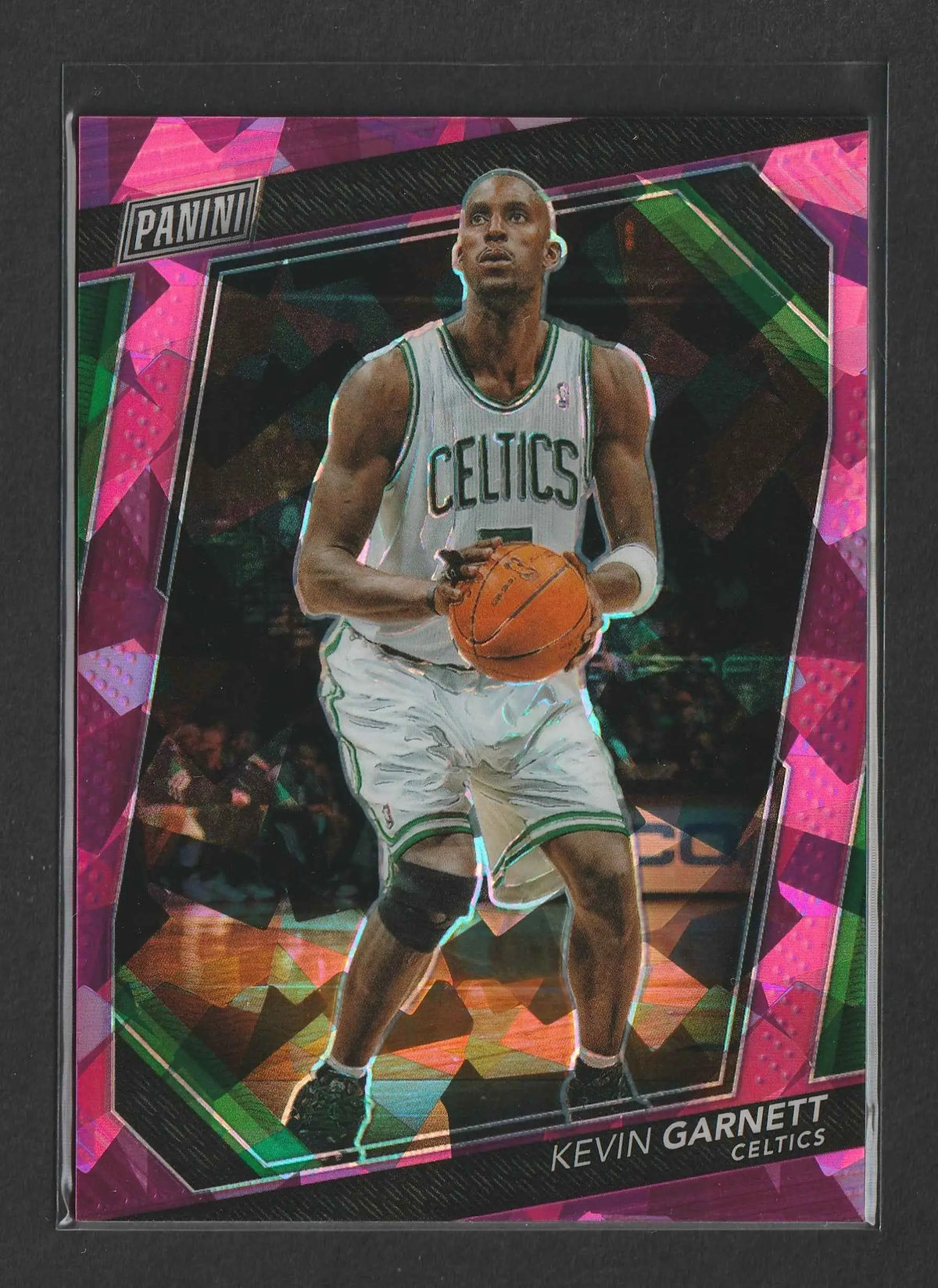 Ein lebhaft pink und grün gemustertes panini trading card von kevin garnett in weißem celtics-trikot mit basketball