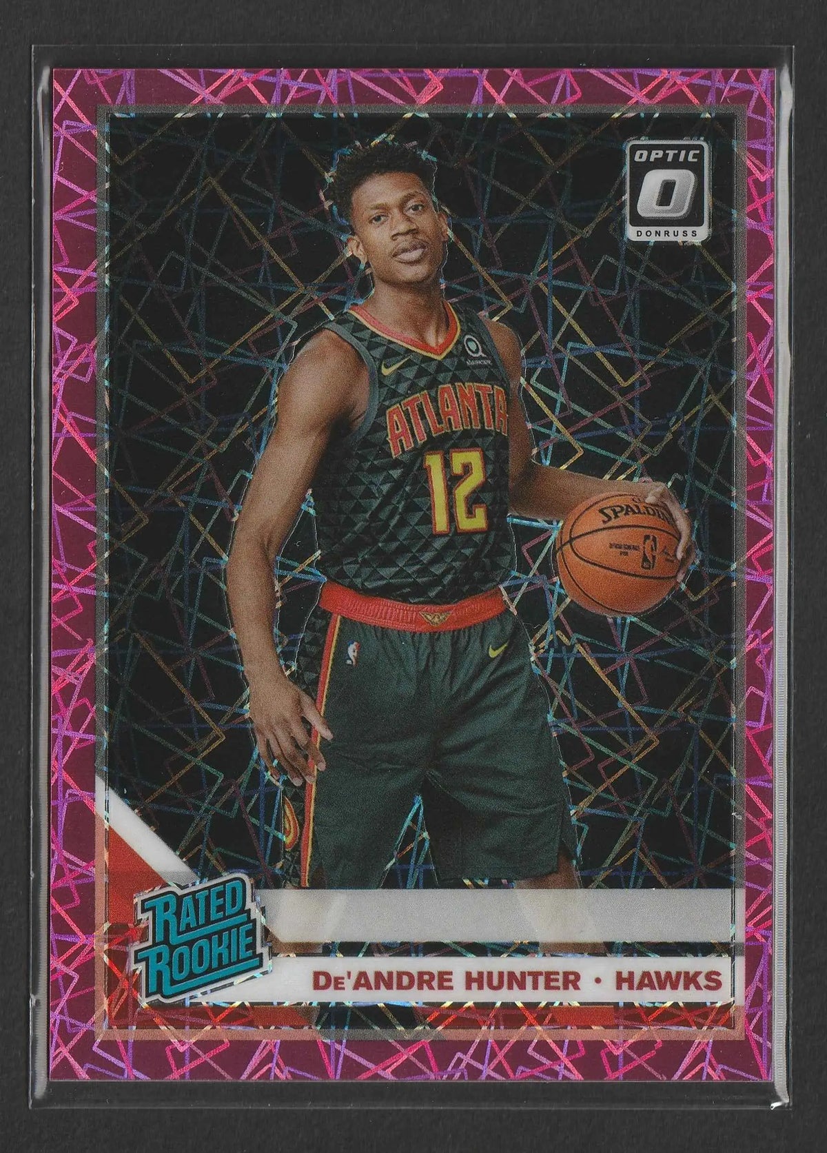 Dies ist eine lebhafte rosa und violette holografische basketball trading card von de’andre hunter im atlanta hawks jersey mit spalding ball