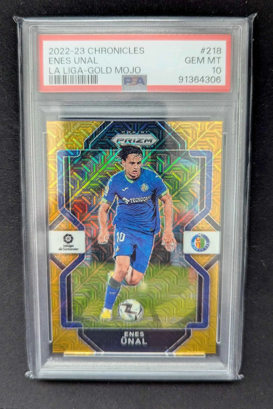 Ein leuchtend gold-blauer prizm trading card von enes ünal in dynamischer fußballpose im protective psa 10 slab
