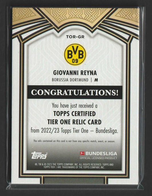 Weiße und goldgerahmte topps tier one relic karte mit giovanni reyna von borussia dortmund und offiziellem bundesliga logo