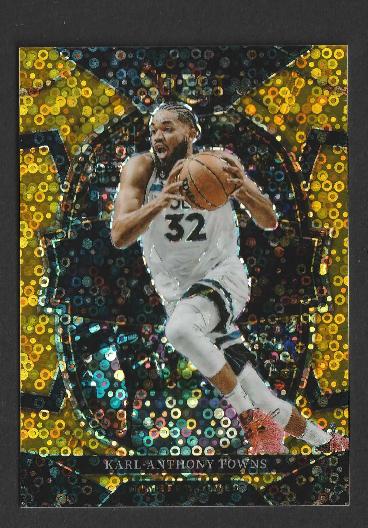 Ein schimmerndes gold und schwarz holografisches basketball trading card von karl-anthony towns in weißem trikot nummer 32