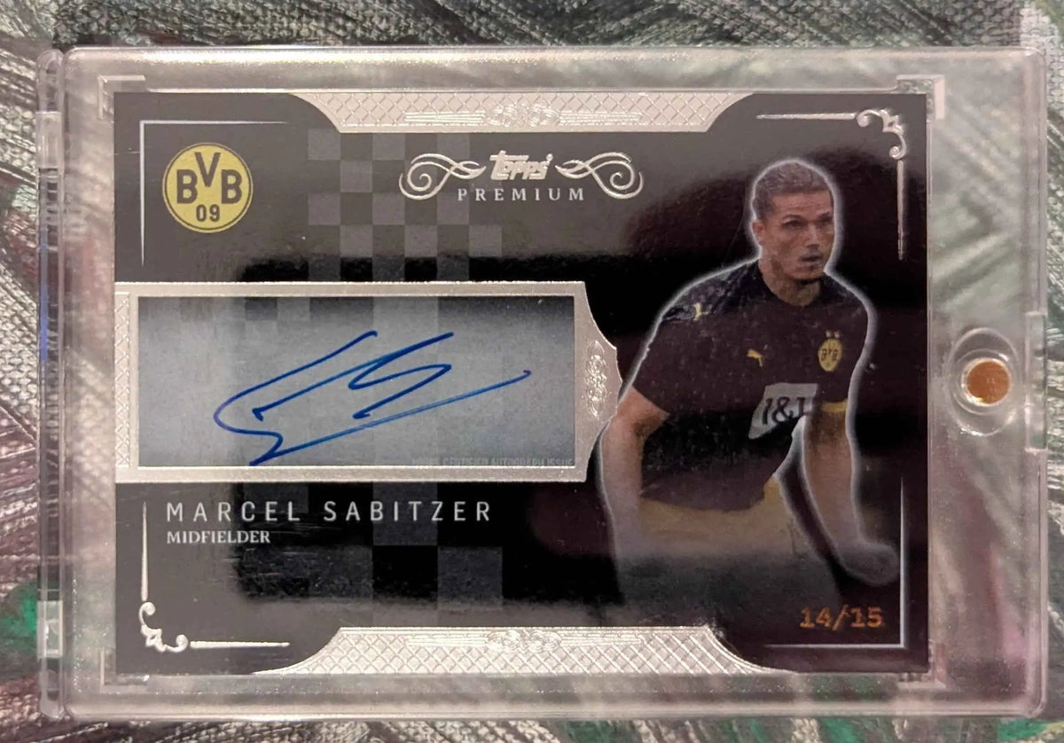 Black und silberne topps premium fussball trading card mit blauem autograph von marcel sabitzer auf grauem stoff