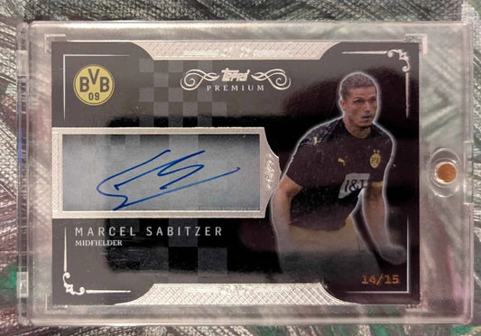 Black und silberne topps premium fussball trading card mit blauem autograph von marcel sabitzer auf grauem stoff