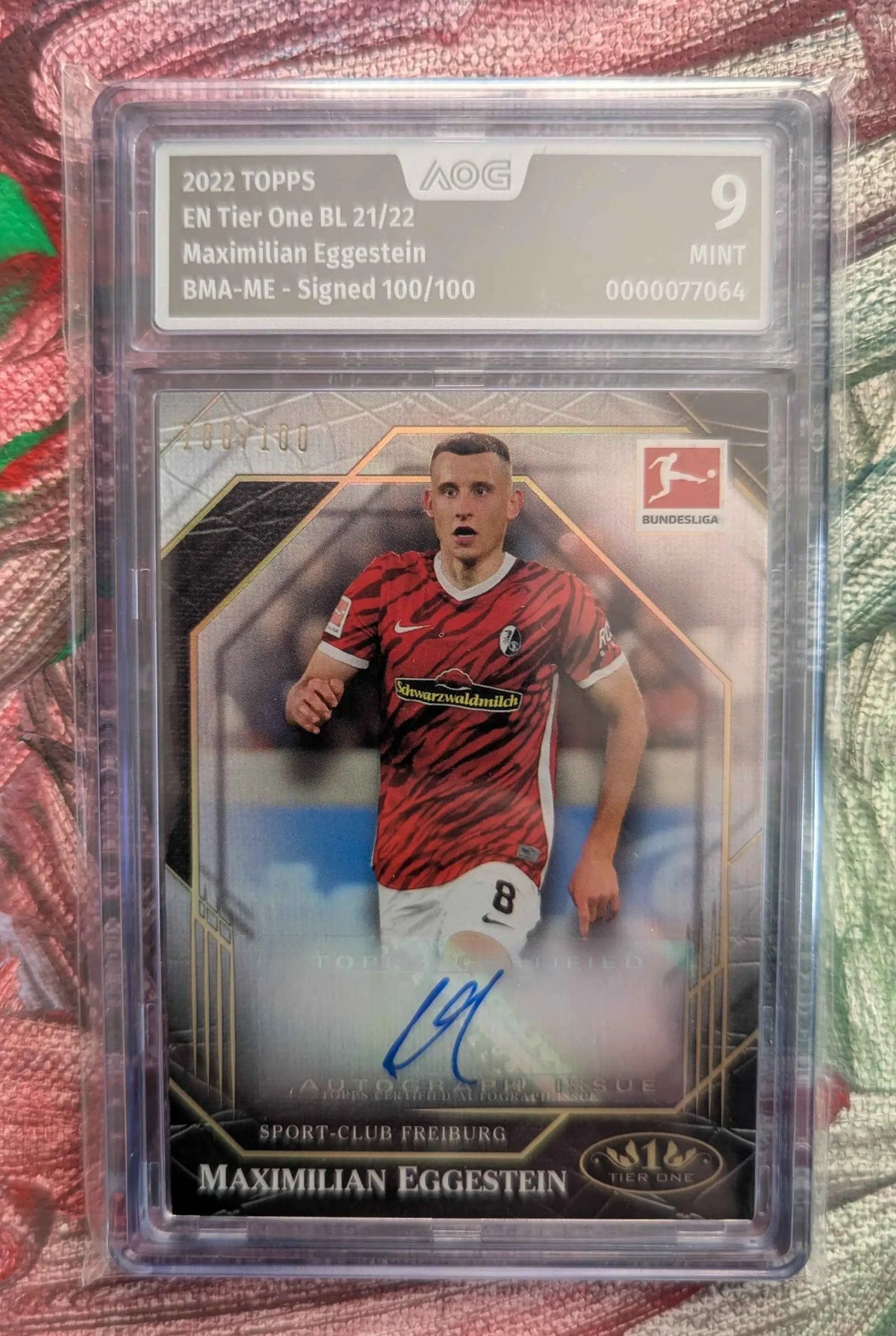 Eine signierte 2022 topps en tier one bundesliga trading card von maximilian eggestein im rot schwarzen trikot in einer schutzhülle