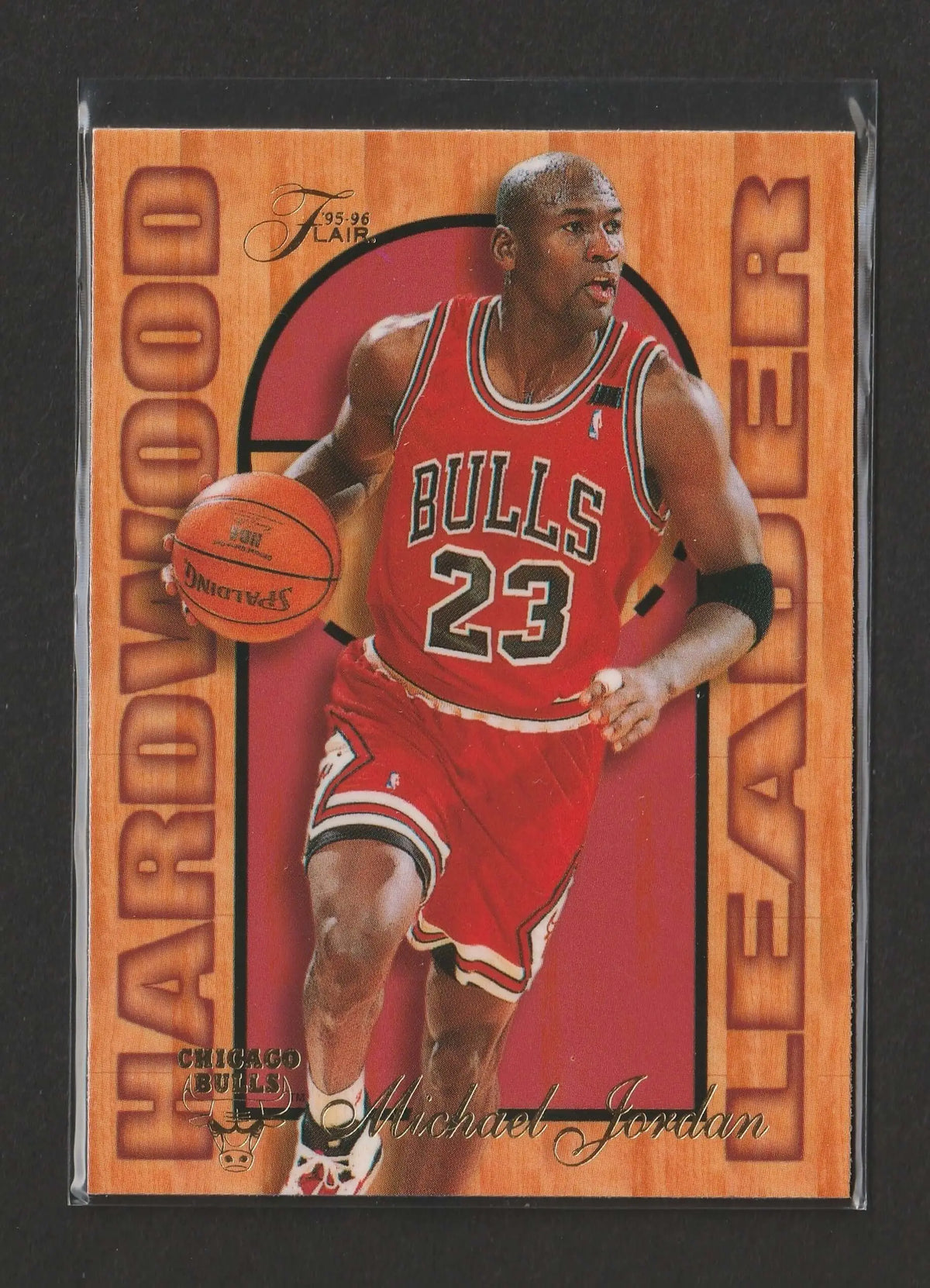 Ein 1995-96 fleer flair hardwood leader trading card mit michael jordan im roten chicago bulls trikot nummer 23 mit basketball