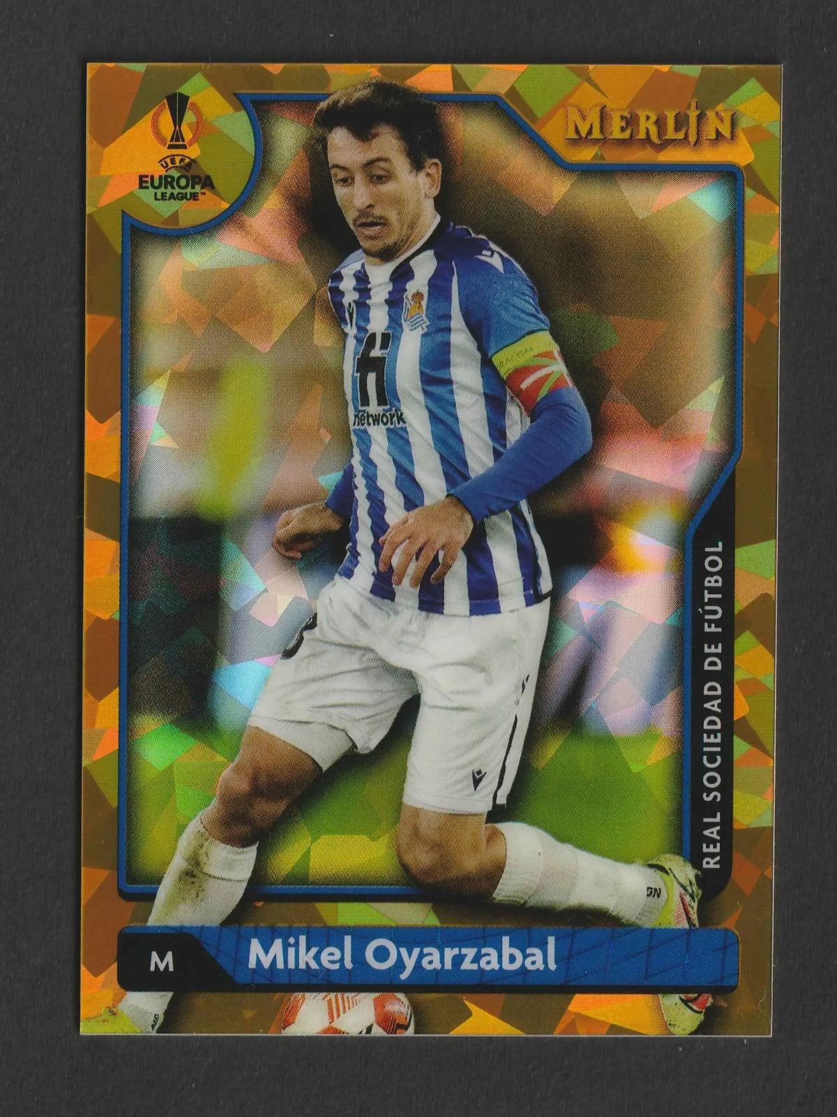 Merlin uefa europa league trading card mit mikel oyarzabal in blau weiß gestreiftem trikot vor orange grünem hintergrund