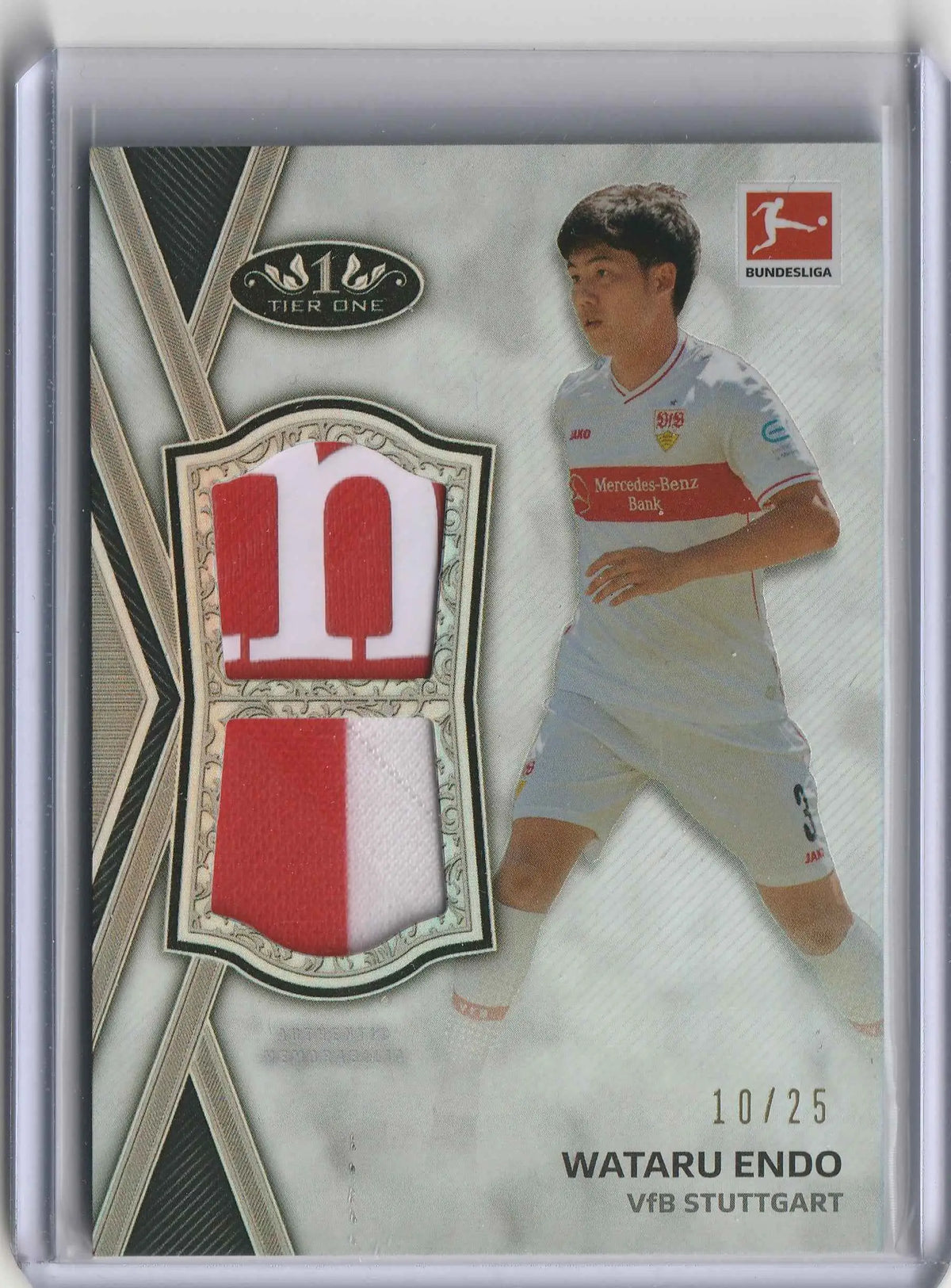 This is a tier one bundesliga trading card of wataru endo with red and white jersey fabric swatches in an ornate frame